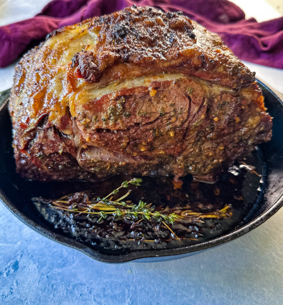 roasted garlic herb butter prime rib in a cast iron skillet