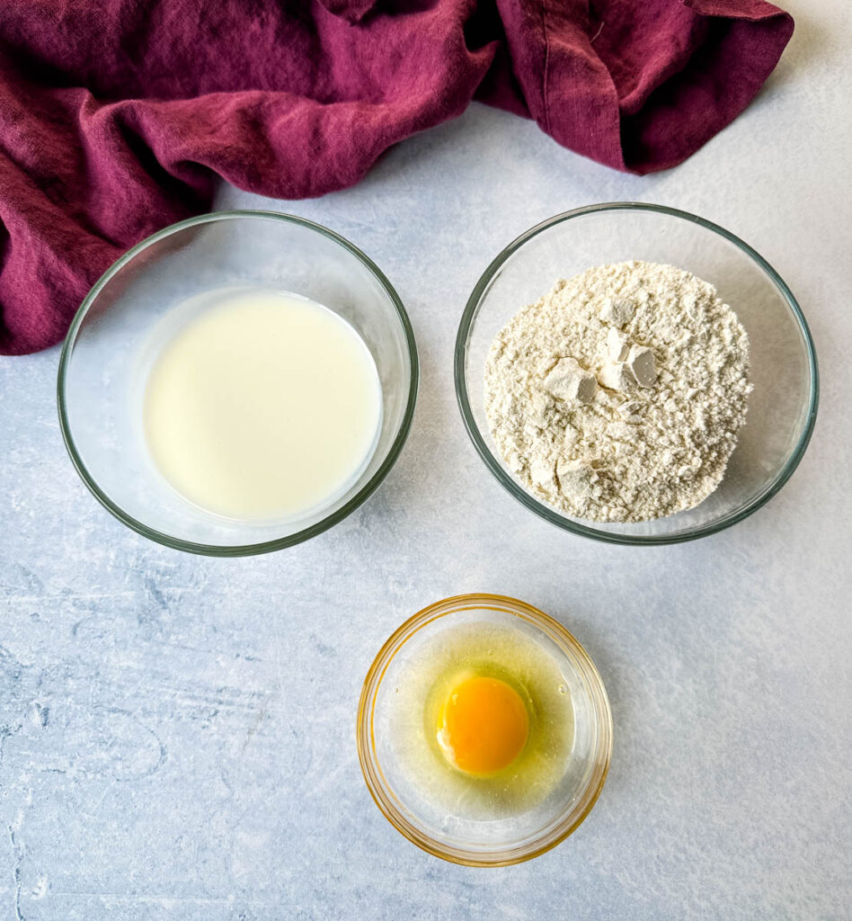 buttermilk, flour, and an egg in separate glass bowls