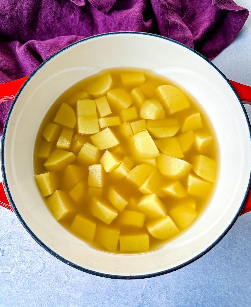 sliced potatoes and broth in a Dutch oven