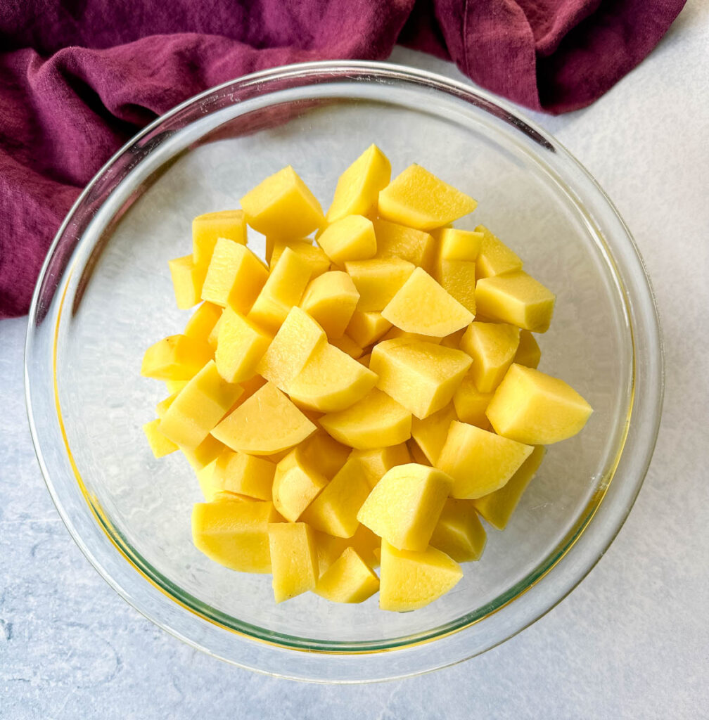 cut/sliced potatoes in a glass bowl