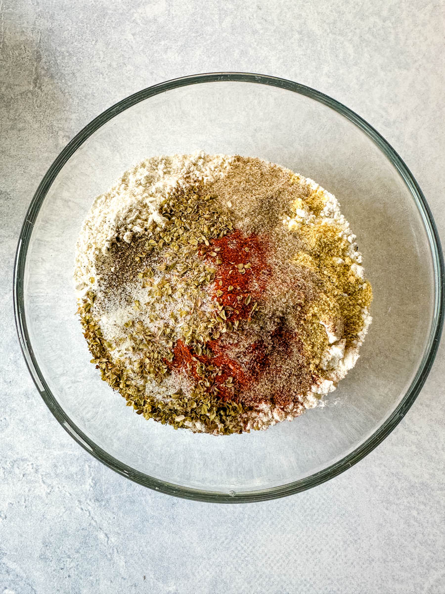 11 herbs and spices and flour in a glass bowl