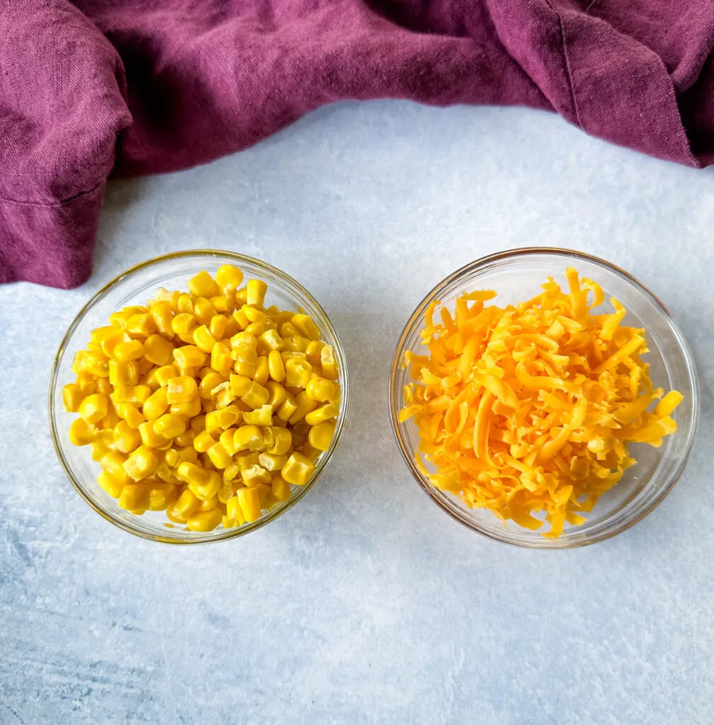 corn and shredded cheese in glass bowls