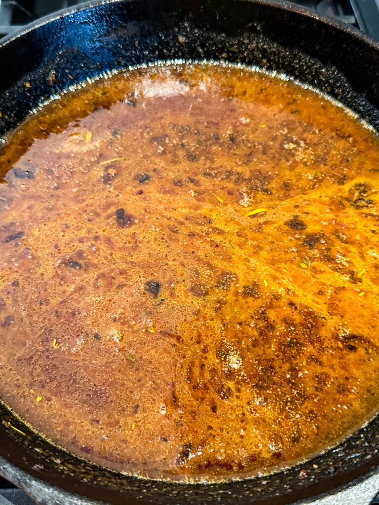 Au Jus gravy sauce in a cast iron skillet
