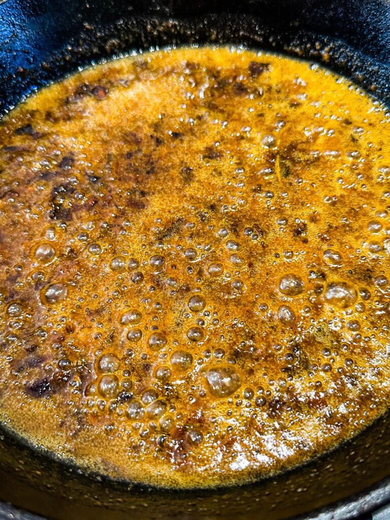 Au Jus gravy sauce in a cast iron skillet
