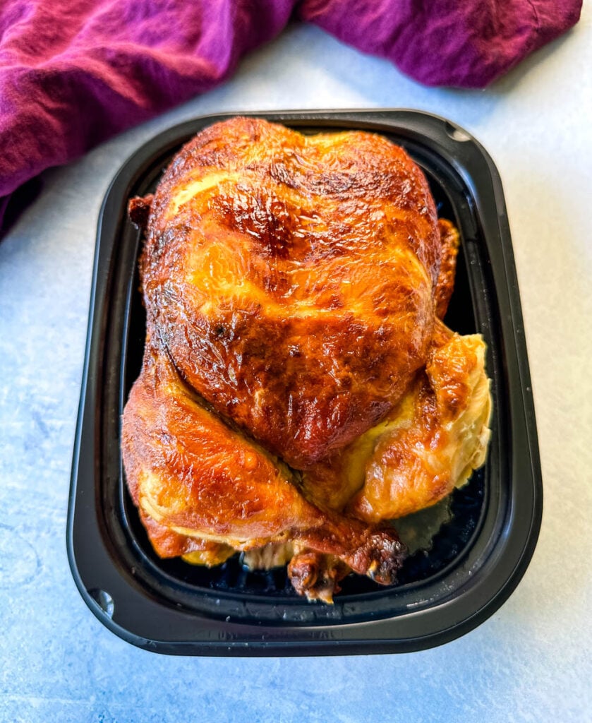 cooked rotisserie chicken in black packaging