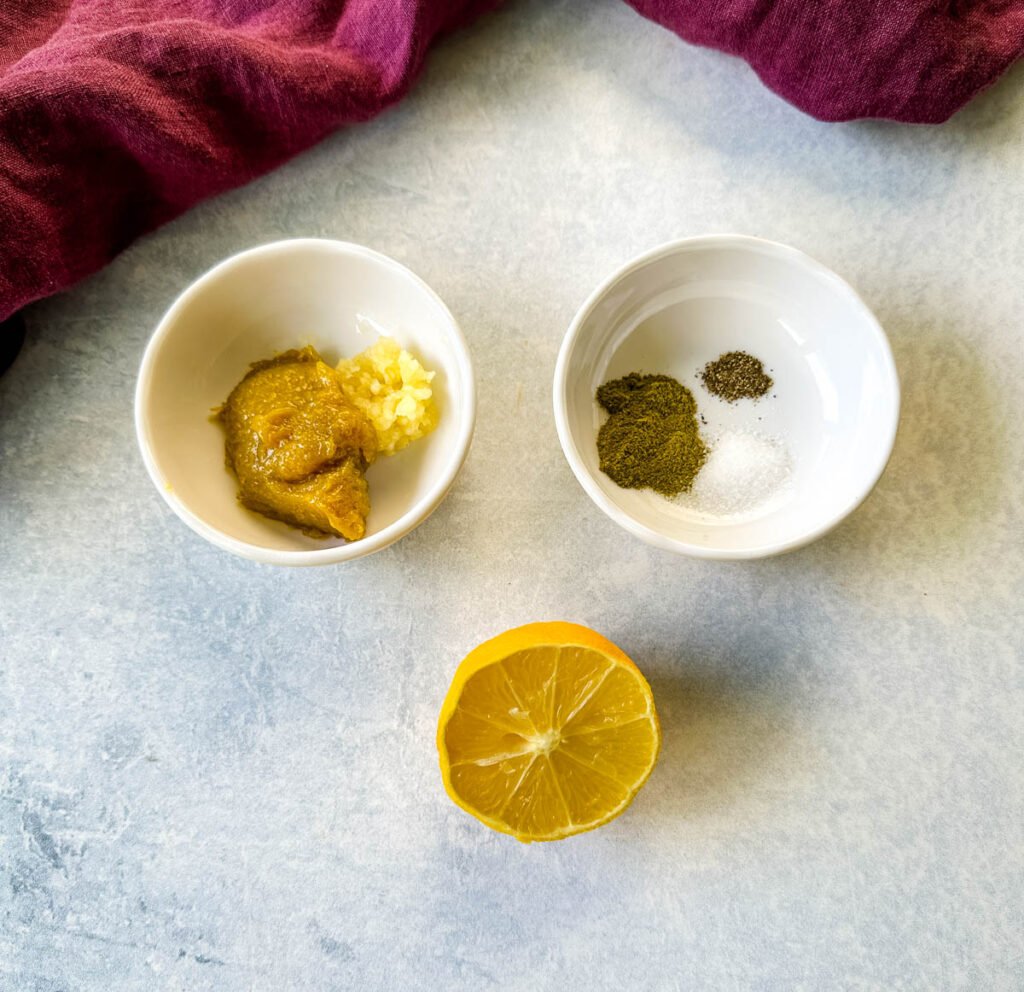 fresh lemon, bouillon, and spices in separate white bowls