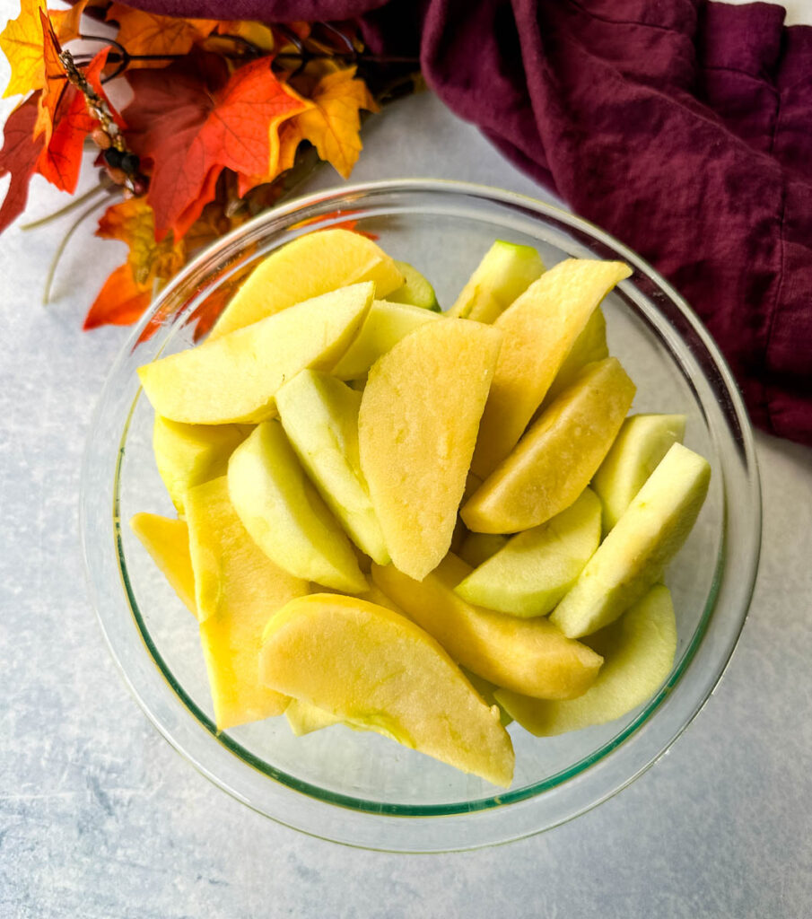 sliced and cored apples in a glass bowl