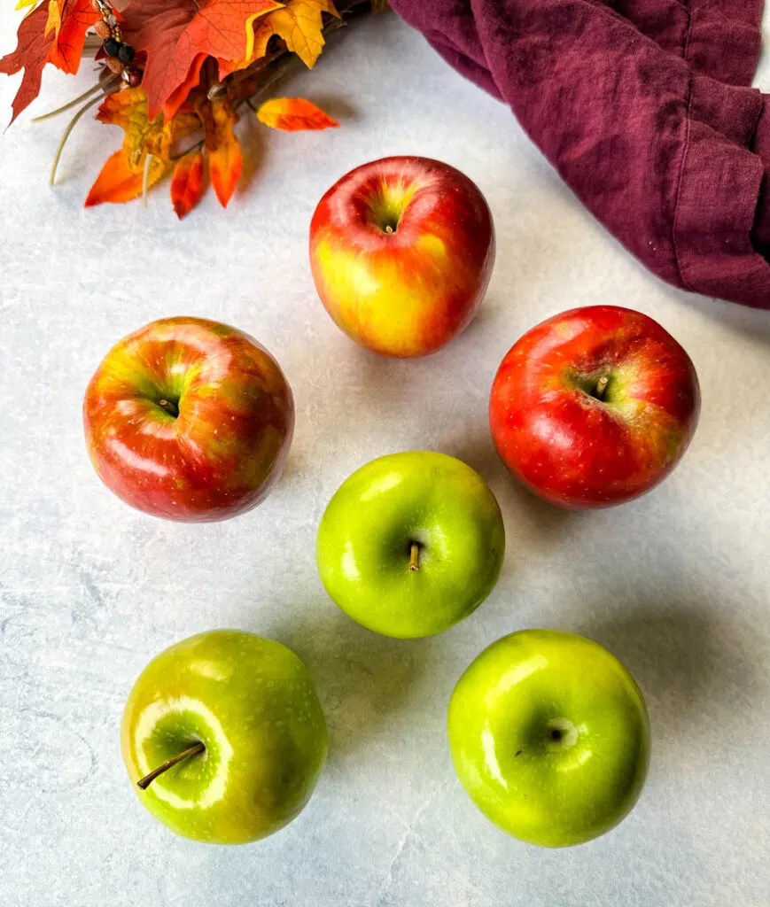Granny smith and honeycrisp apples on a flat surface