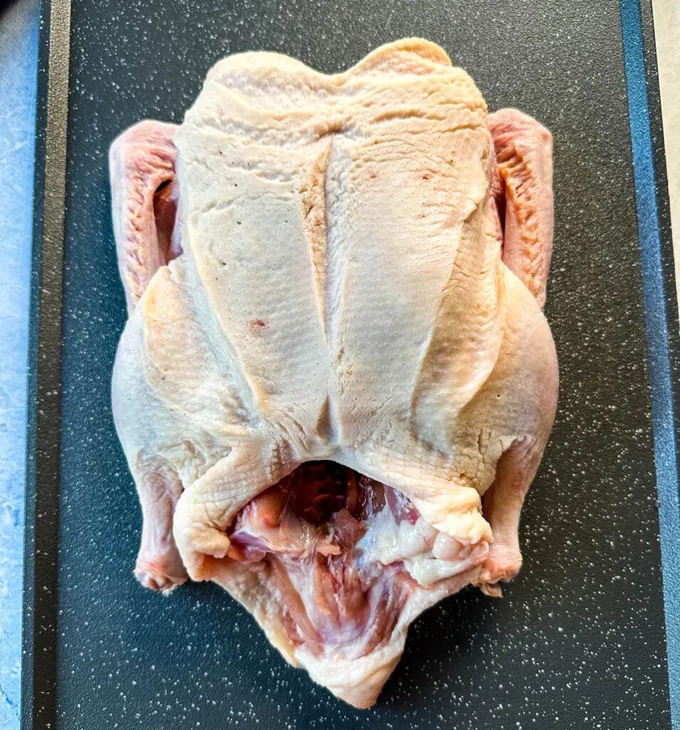 raw whole duck on a sheet pan