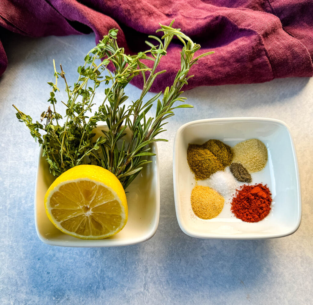 lemon, parsley, rosemary, and spices in separate white bowls