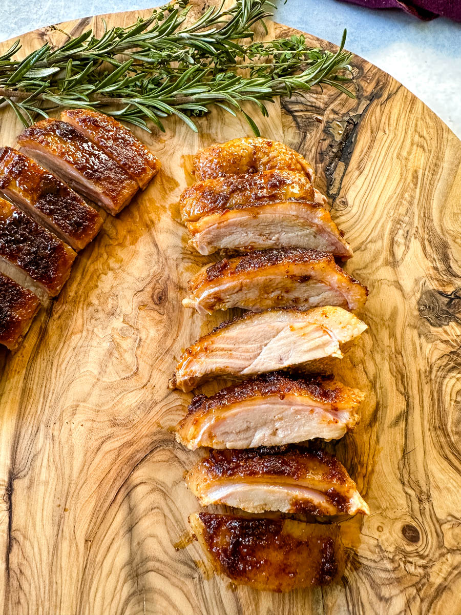 slow cooker Crockpot duck breast sliced on a wooden cutting board