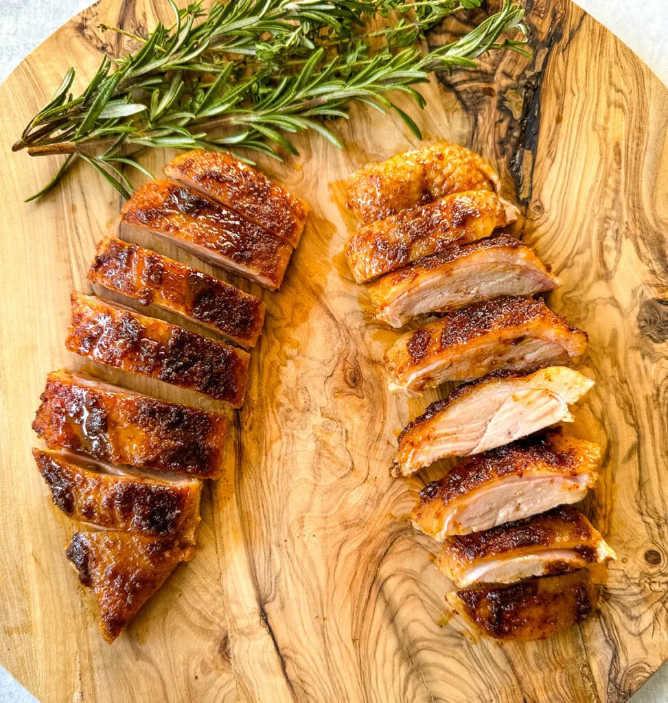 slow cooker Crockpot duck breast sliced on a wooden cutting board