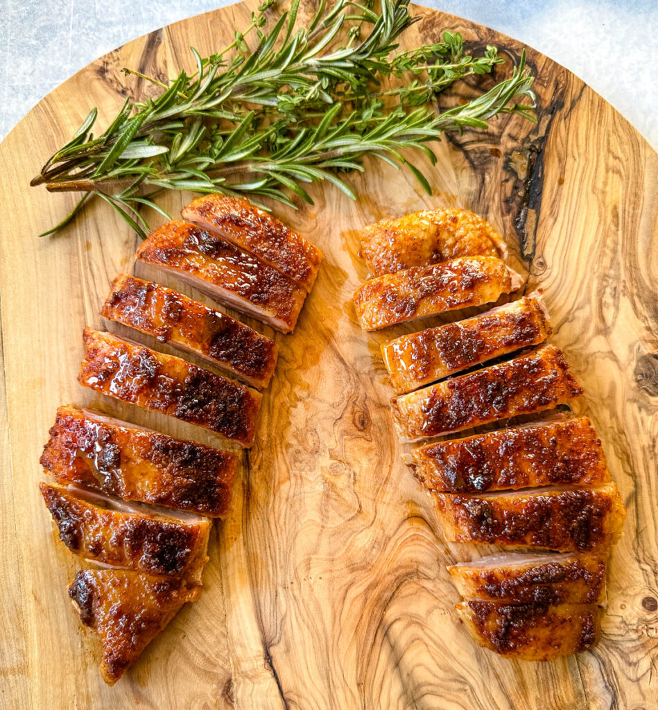 slow cooker Crockpot duck breast sliced on a wooden cutting board