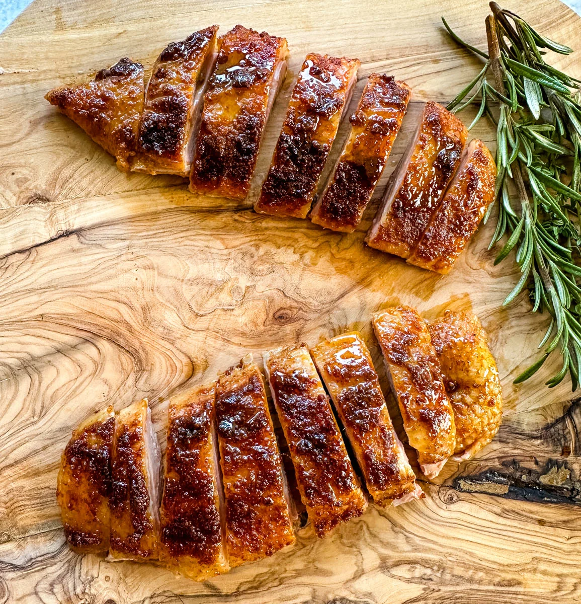 smoked duck breast sliced on a wooden cutting board