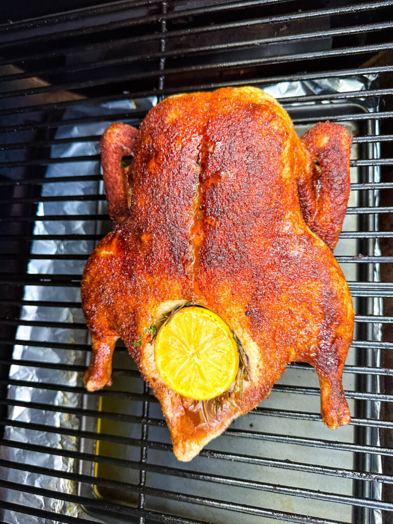 whole duck on a Traeger smoker pellet grill stuffed with lemon and herbs