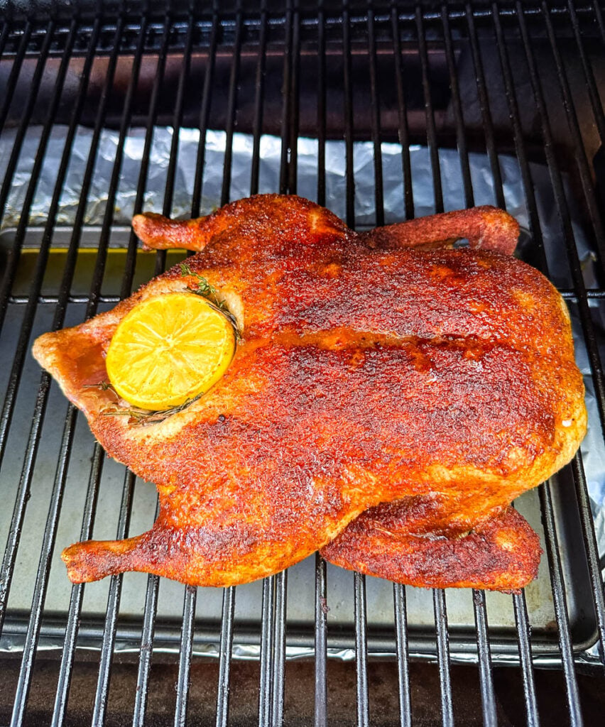 whole duck on a Traeger smoker pellet grill stuffed with lemon and herbs