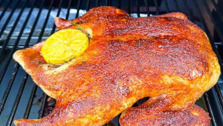 whole duck on a Traeger smoker pellet grill stuffed with lemon and herbs