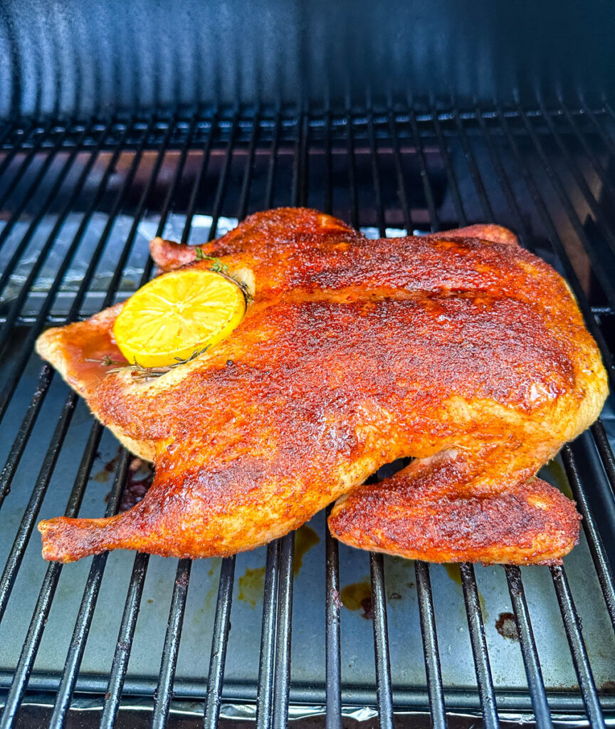 whole duck on a Traeger smoker pellet grill stuffed with lemon and herbs