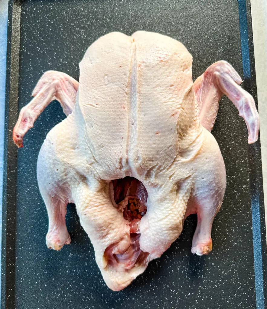 raw whole duck on a sheet pan