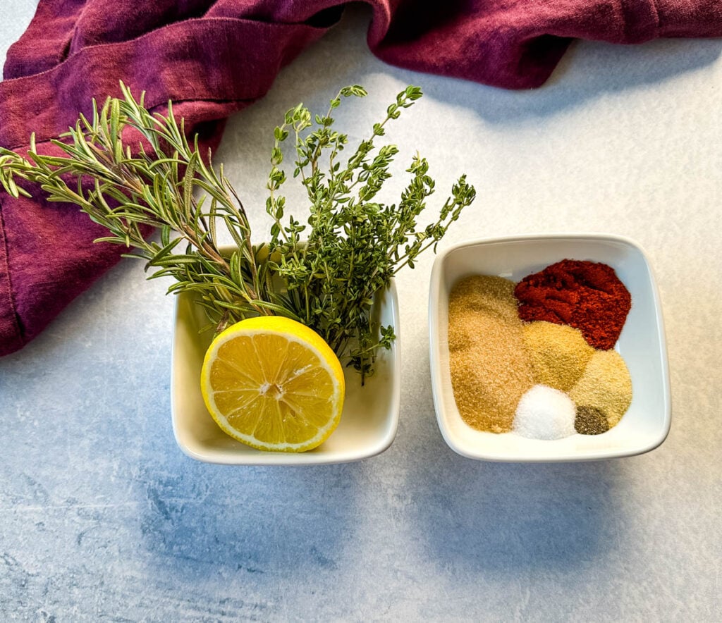 lemon, parsley, rosemary, and spices in separate white bowls
