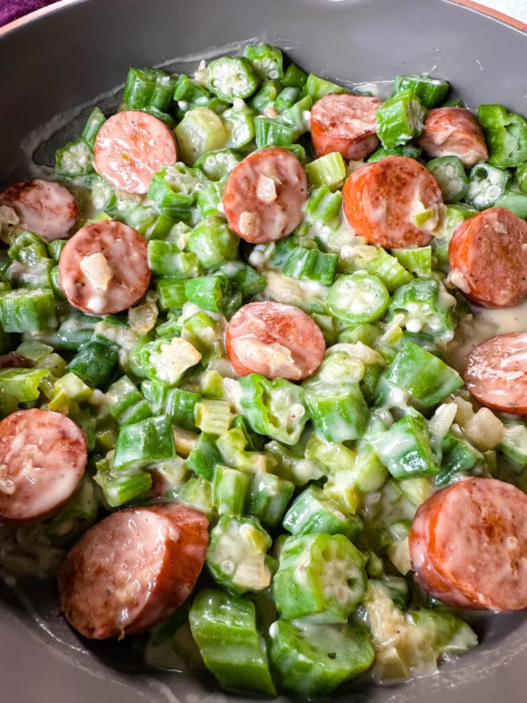 smothered okra with sausage and gravy in a skillet