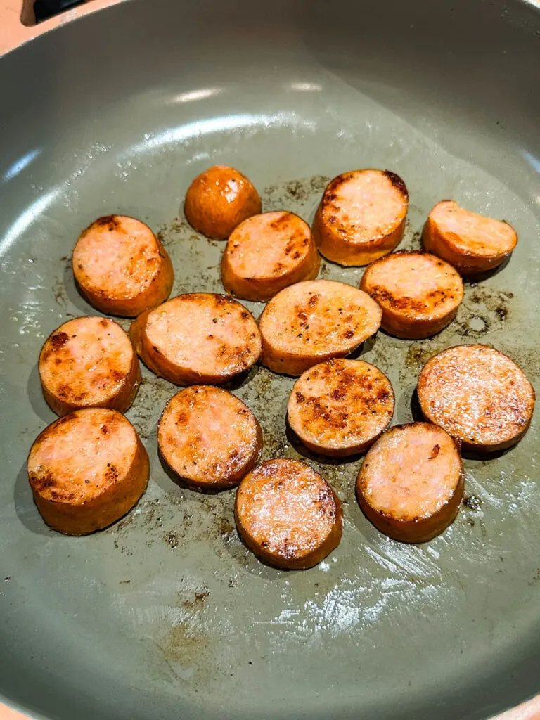 cooked andouille sausage in a skillet