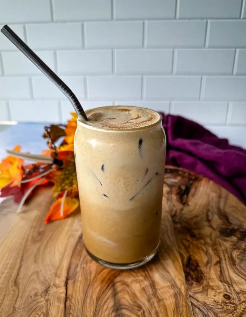 pumpkin cream cold brew coffee in a glass cup with a straw