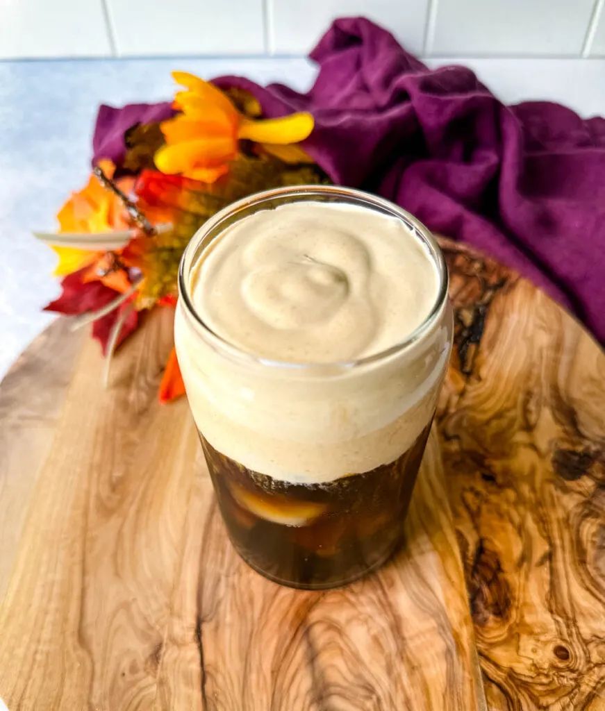 pumpkin cream cold brew coffee in a glass cup with a straw