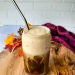 pumpkin cream cold brew coffee in a glass cup with a straw