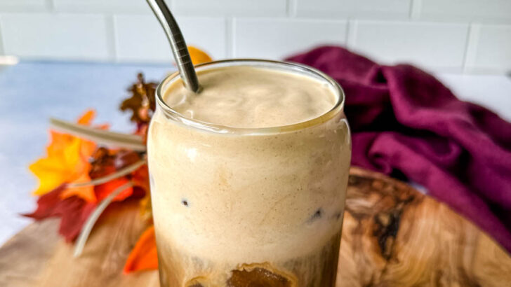 pumpkin cream cold brew coffee in a glass cup with a straw