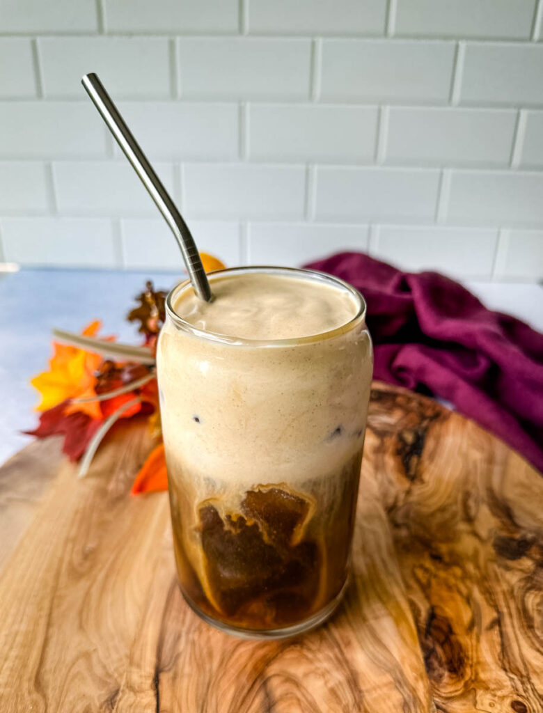 pumpkin cream cold brew coffee in a glass cup with a straw