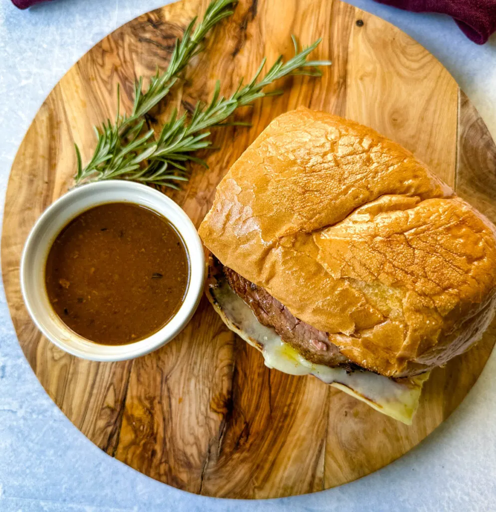 French dip sandwich on a plate with au jus sauce