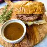 French dip sandwich on a plate with au jus sauce