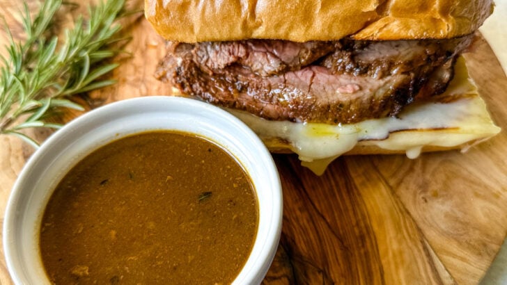 French dip sandwich on a plate with au jus sauce