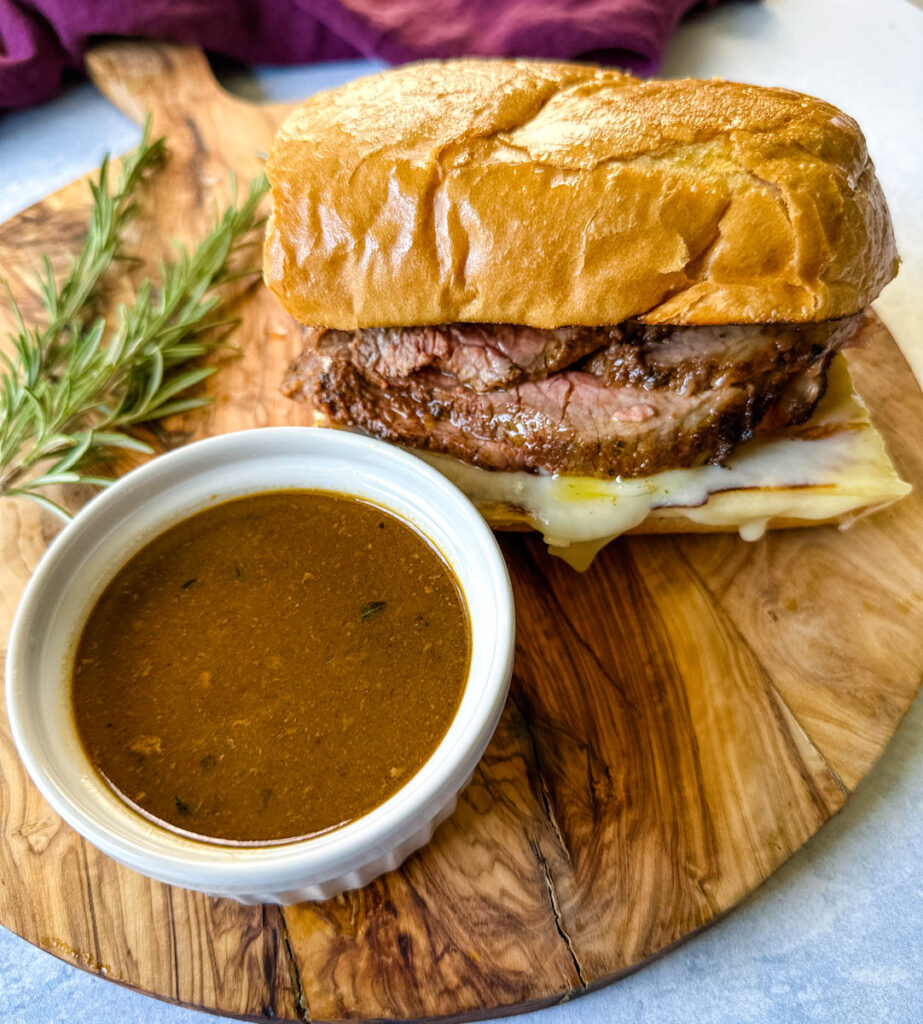 French dip sandwich on a plate with au jus sauce