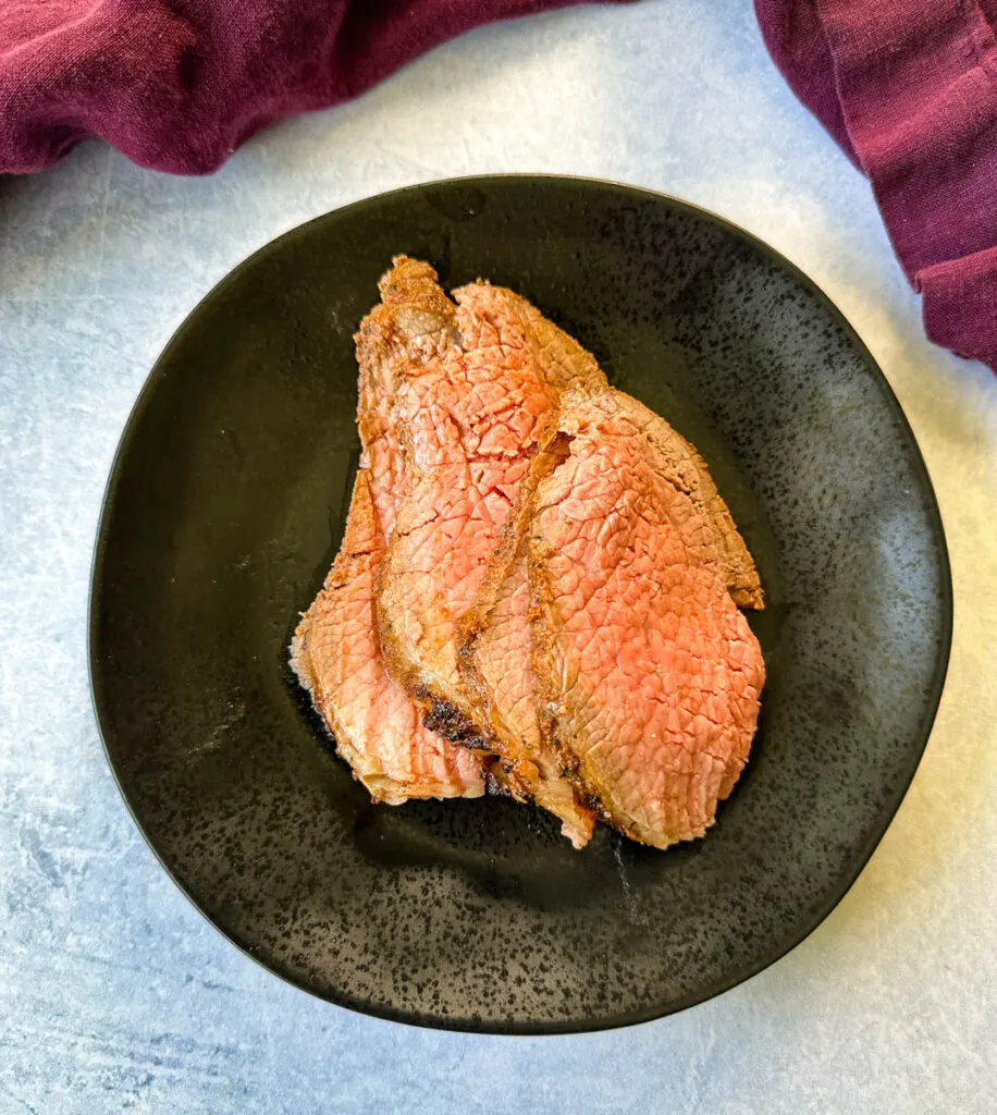 sliced roast beef on a black plate