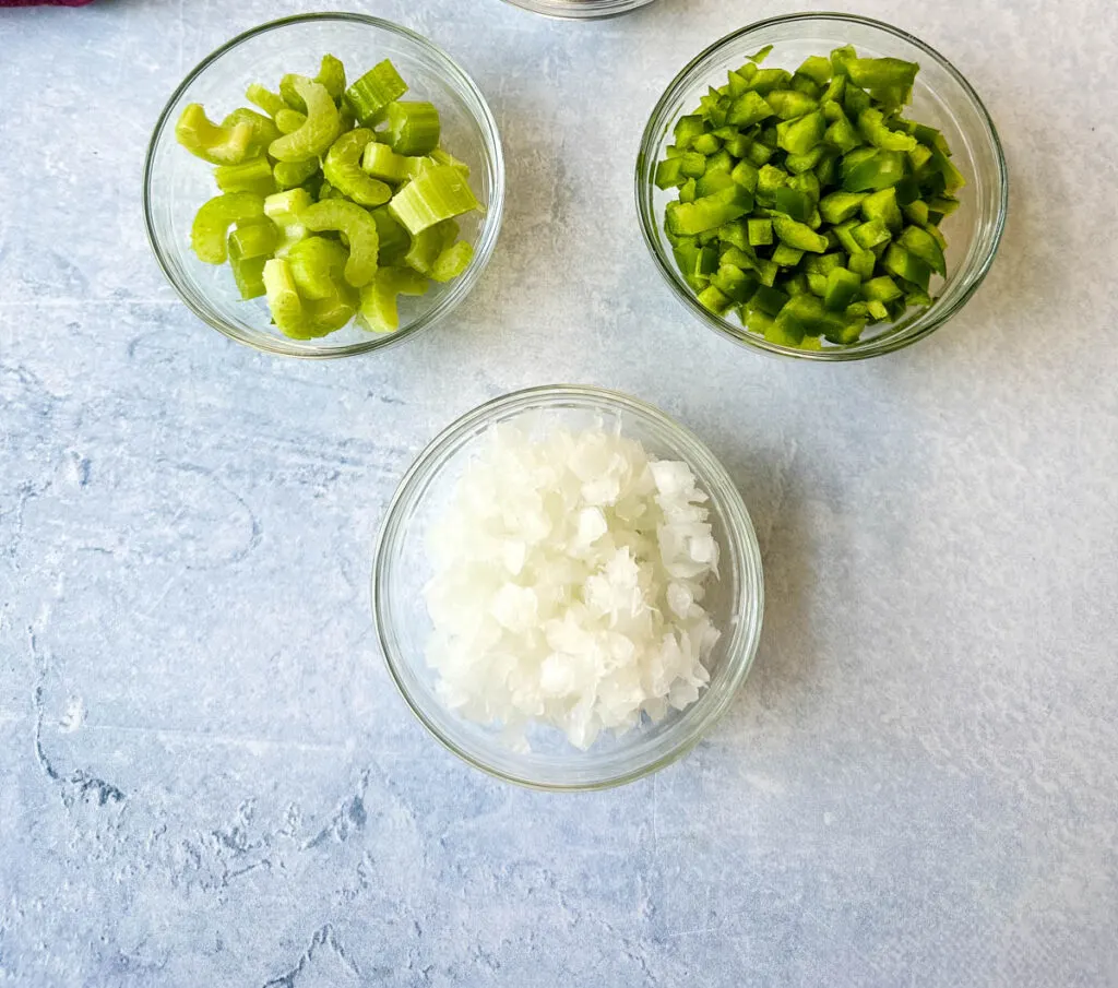 sliced green peppers, celery, and onions in separate glass bowls