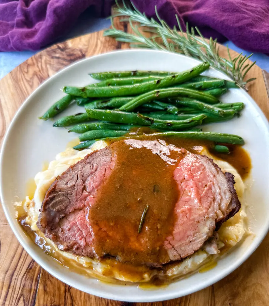 air fryer roast beef with mashed potatoes, gravy, and green beans on a plate