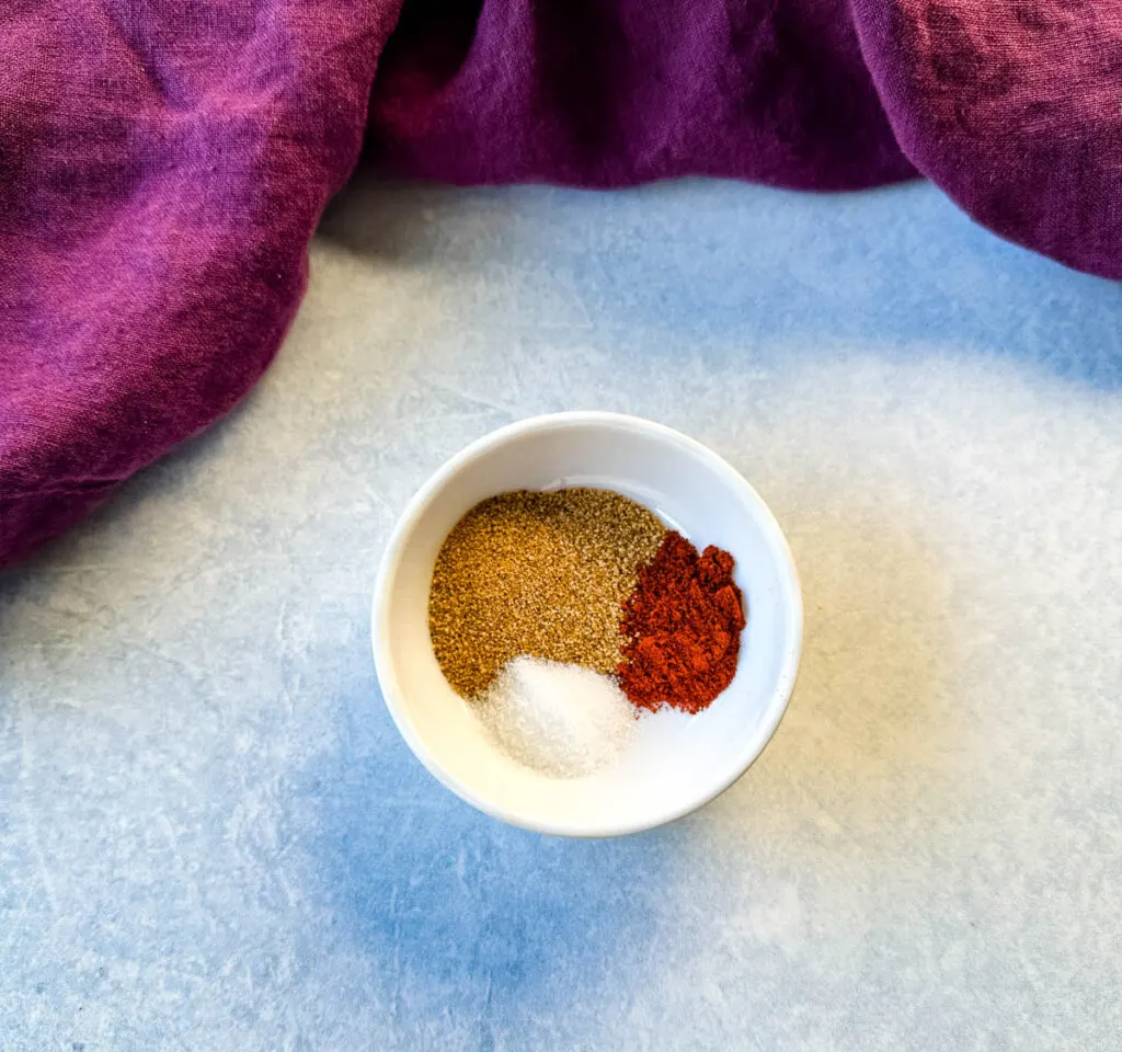 Creole seasoning, smoked paprika, and salt in a white bowl