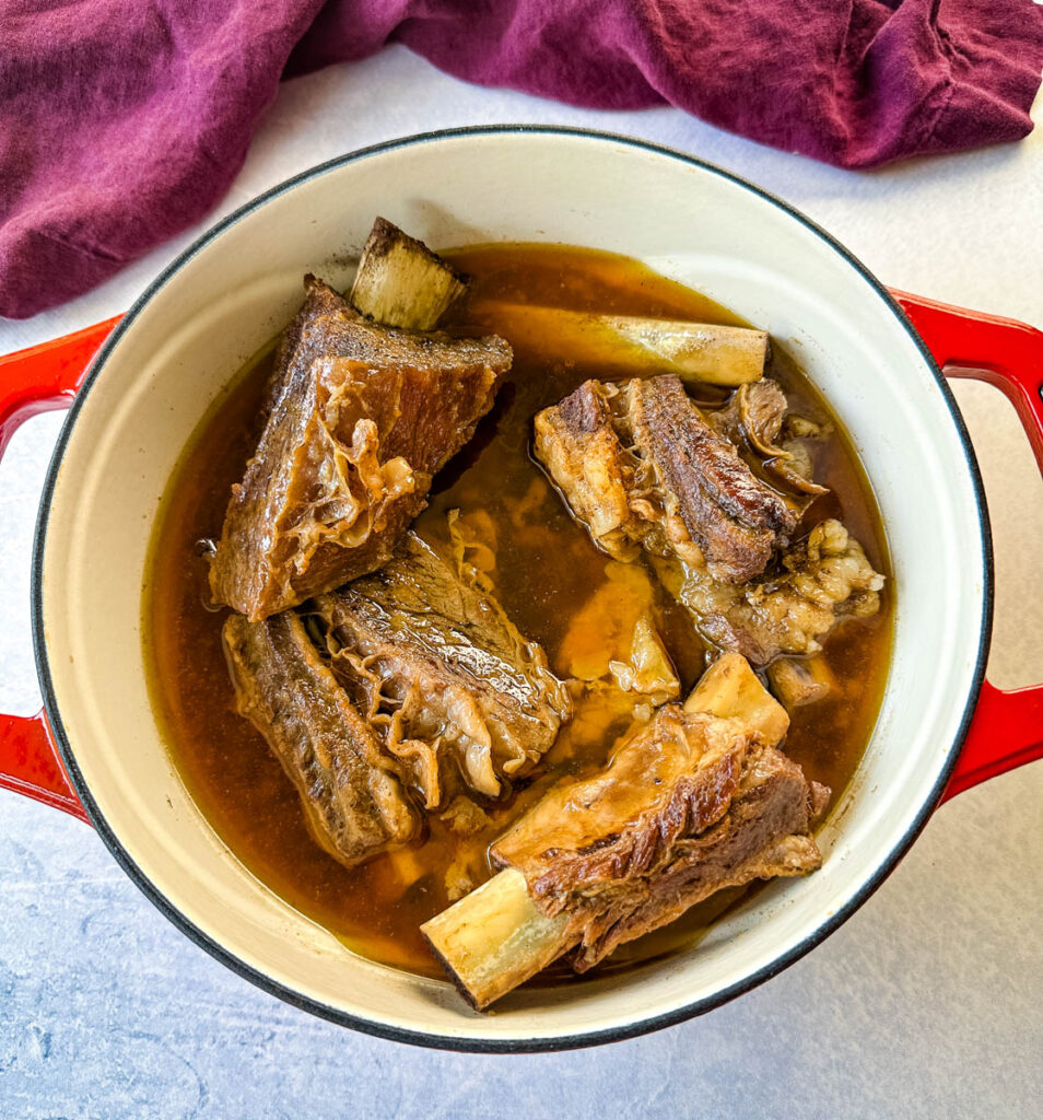 cooked braised beef short ribs in a Dutch oven with broth