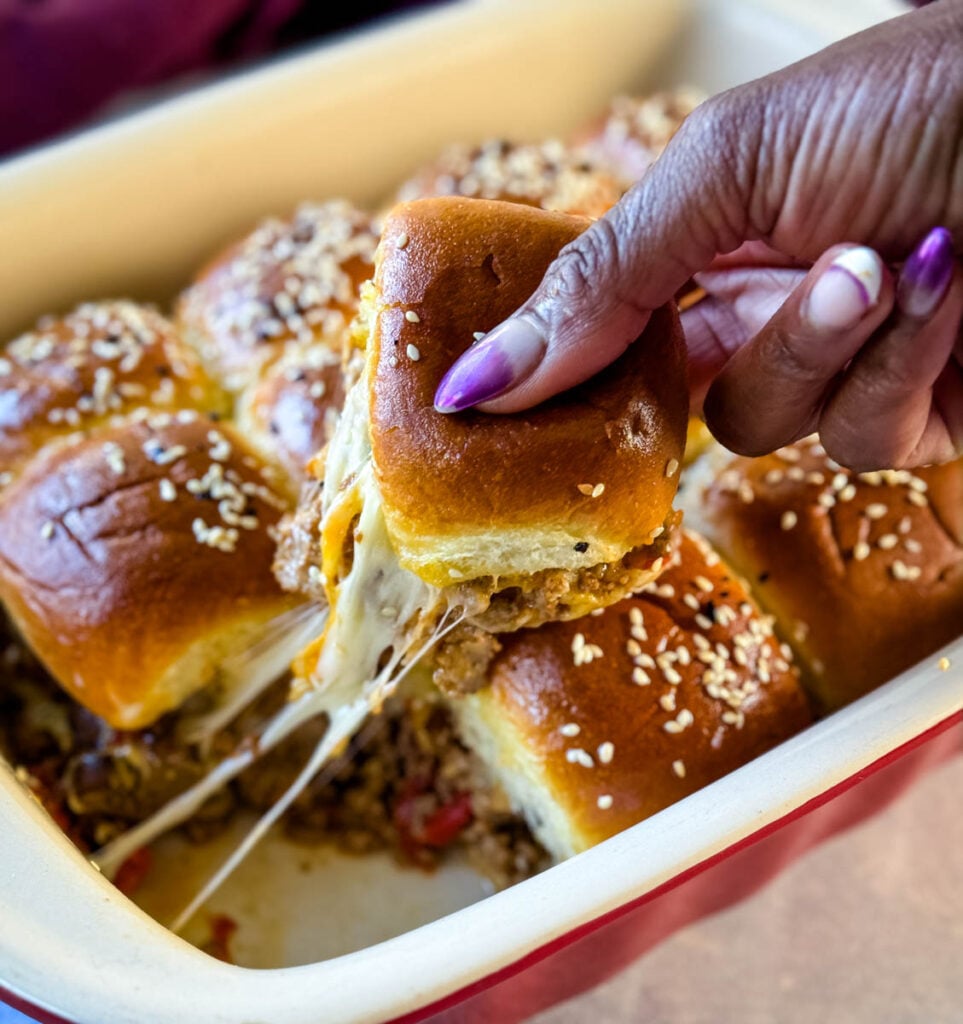 person holding Kings Hawaiian Sliders with cheese