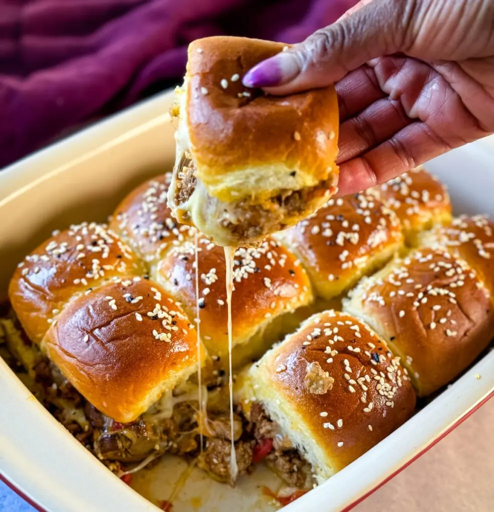 person holding Kings Hawaiian Sliders with cheese