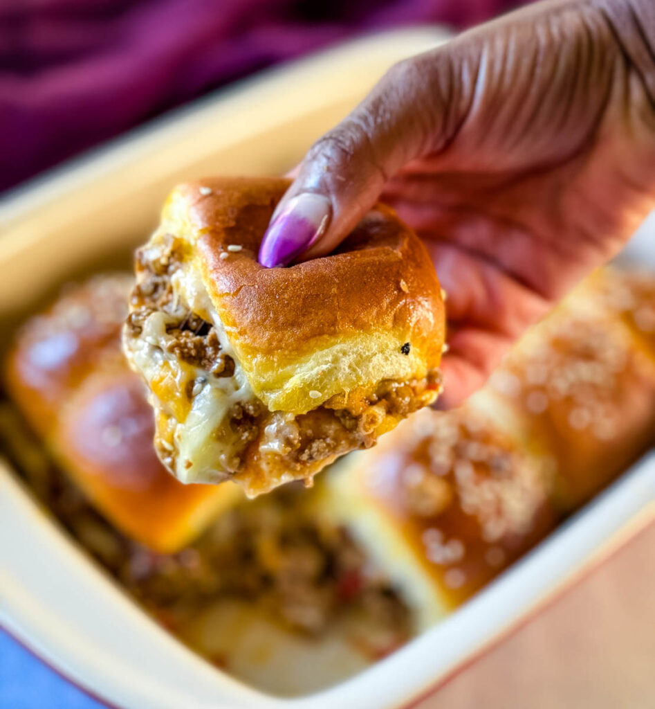 person holding Kings Hawaiian Sliders with cheese