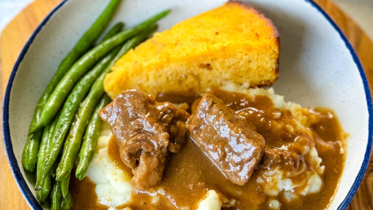beef tips and gravy with green beans and cornbread in a bowl
