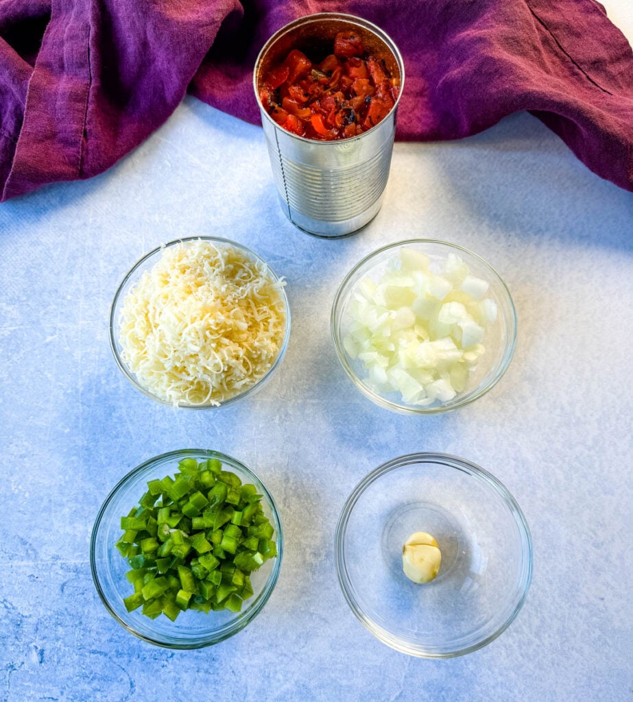 canned fire roasted tomatoes, diced onions, diced green peppers, garlic, and grated parmesan in separate glass bowls