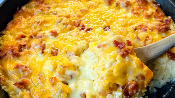 hashbrown casserole with bacon and cheese in a cast iron skillet