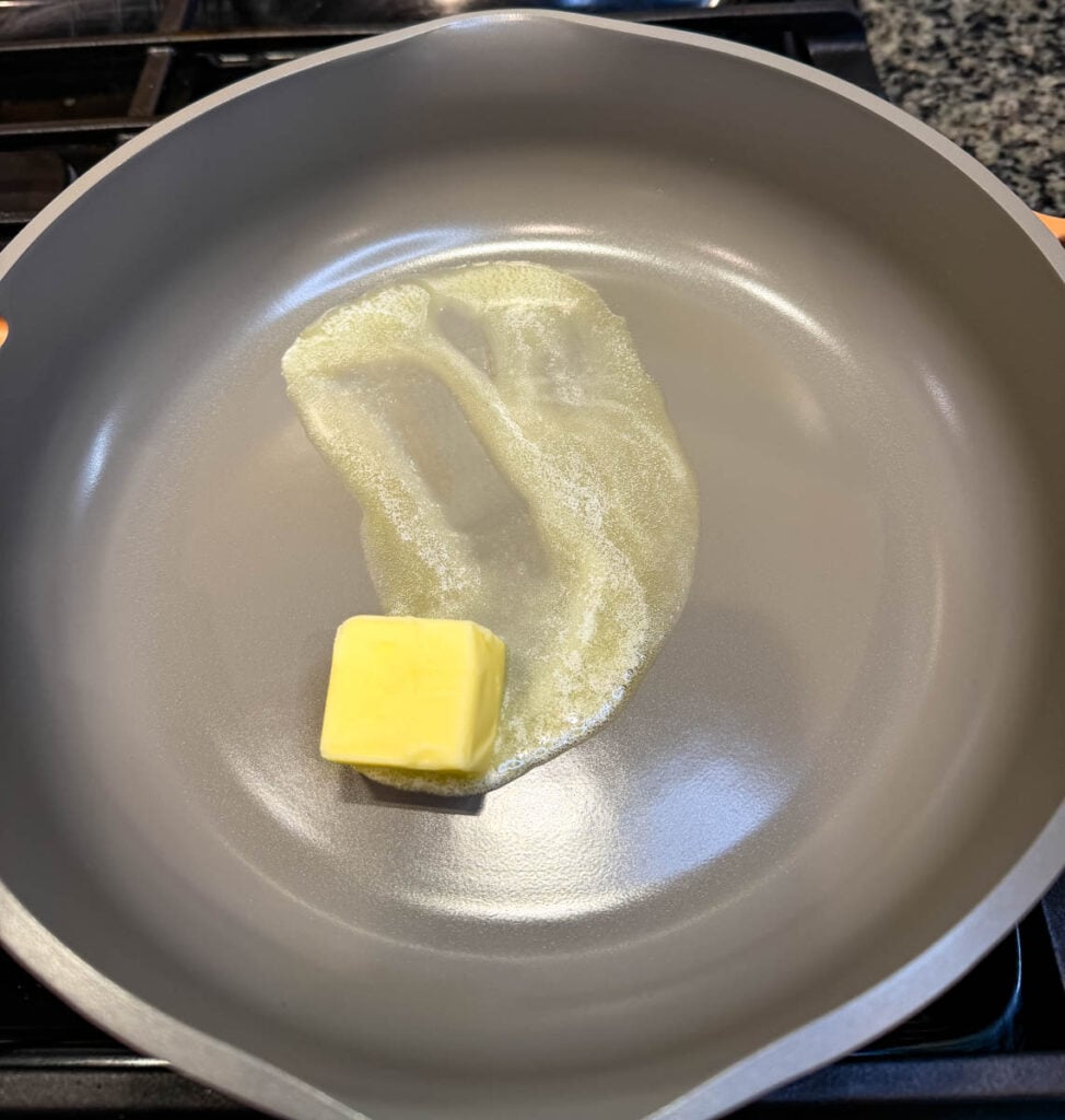 Butter melts in a skillet as the first step for making homemade turkey gravy from drippings.