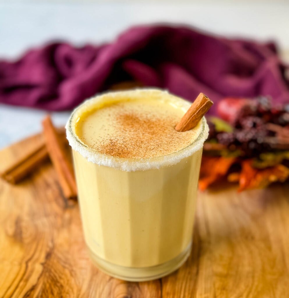 spiked eggnog with liquor and cinnamon on a flat surface