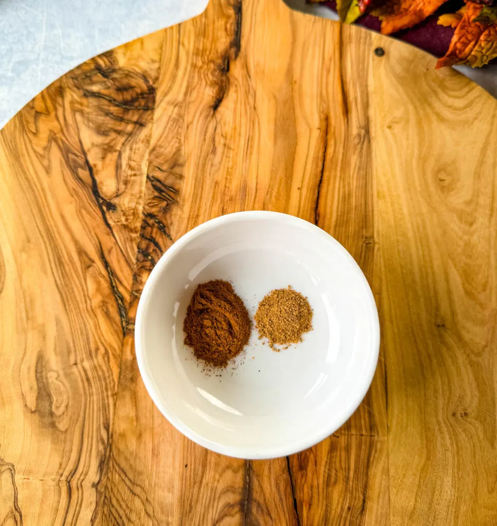 ground cinnamon and ground nutmeg in a white bowl