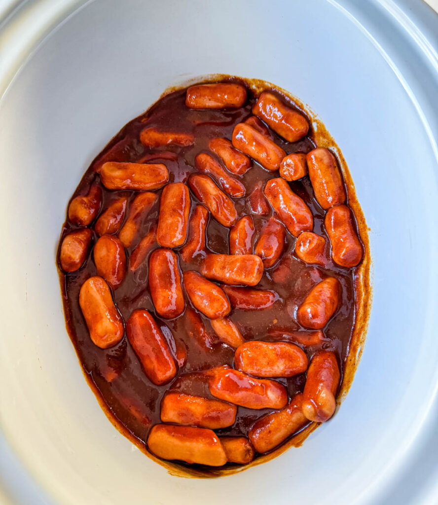 little smokies in a slow cooker Crockpot with BBQ sauce, brown sugar, chili powder, garlic powder, and smoked paprika